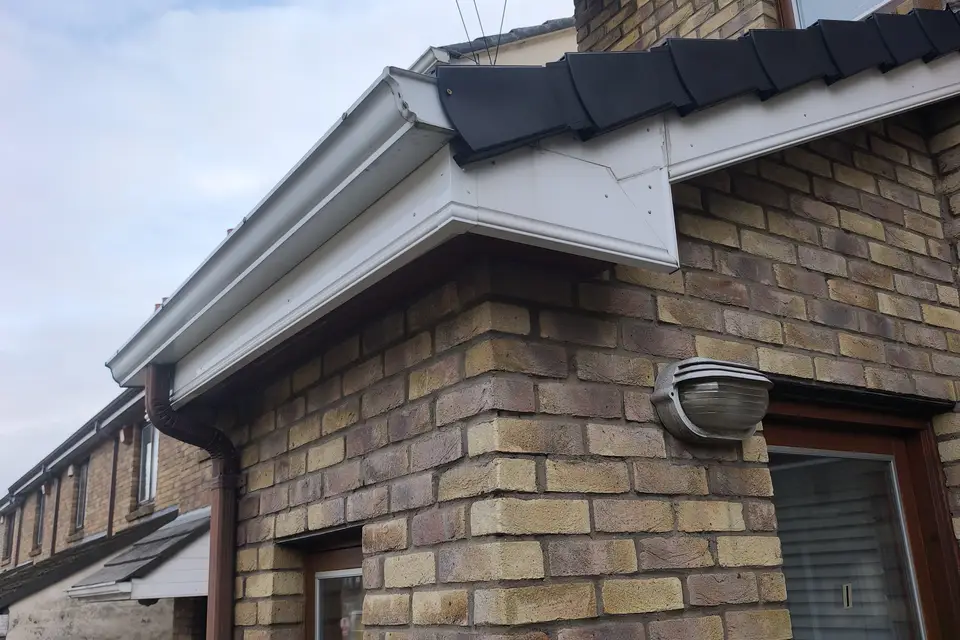 White soffit and black fascia on a brick house