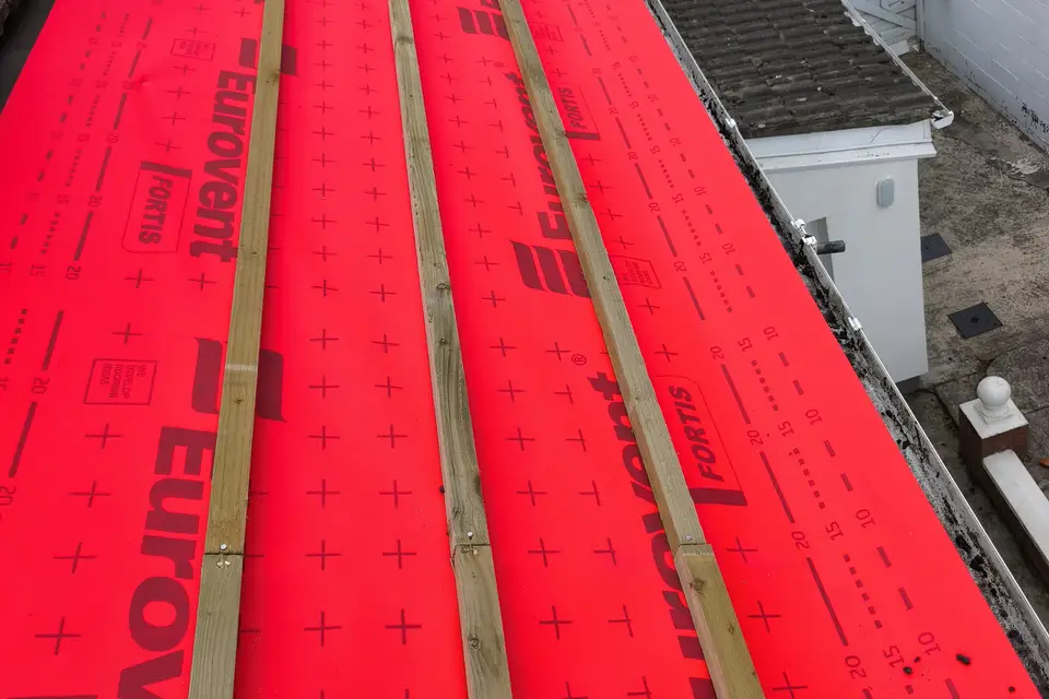Re-roofing in progress with new membrane and battens across the slope