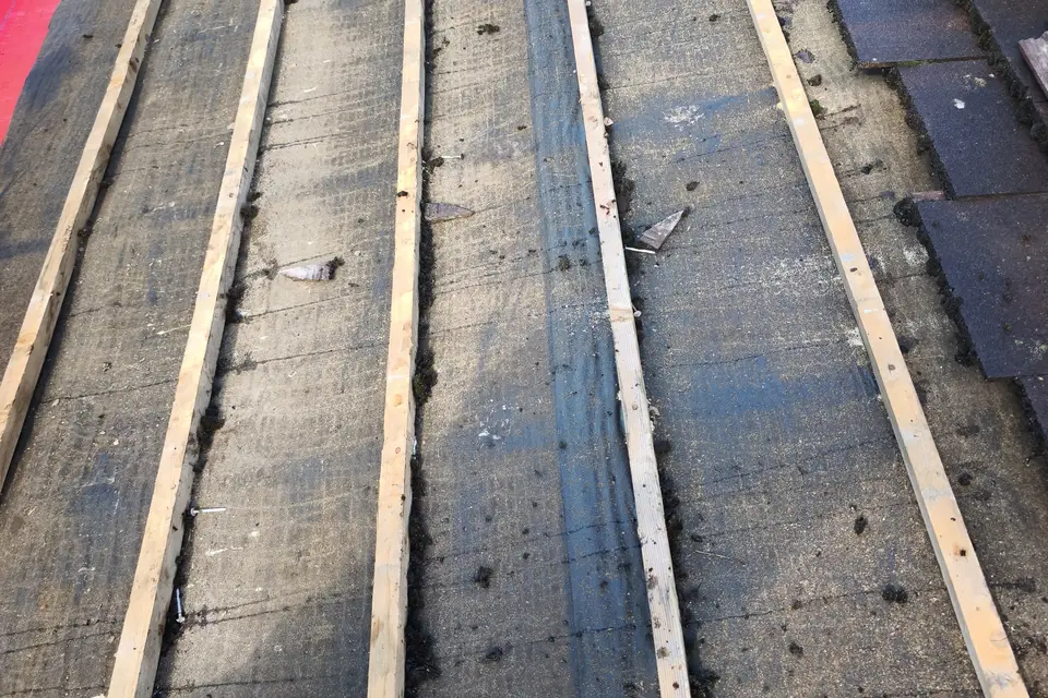 Old roof covering stripped back to the battens before new membrane